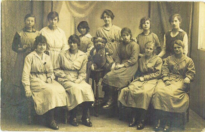 Teddy on a stool surrounded by women