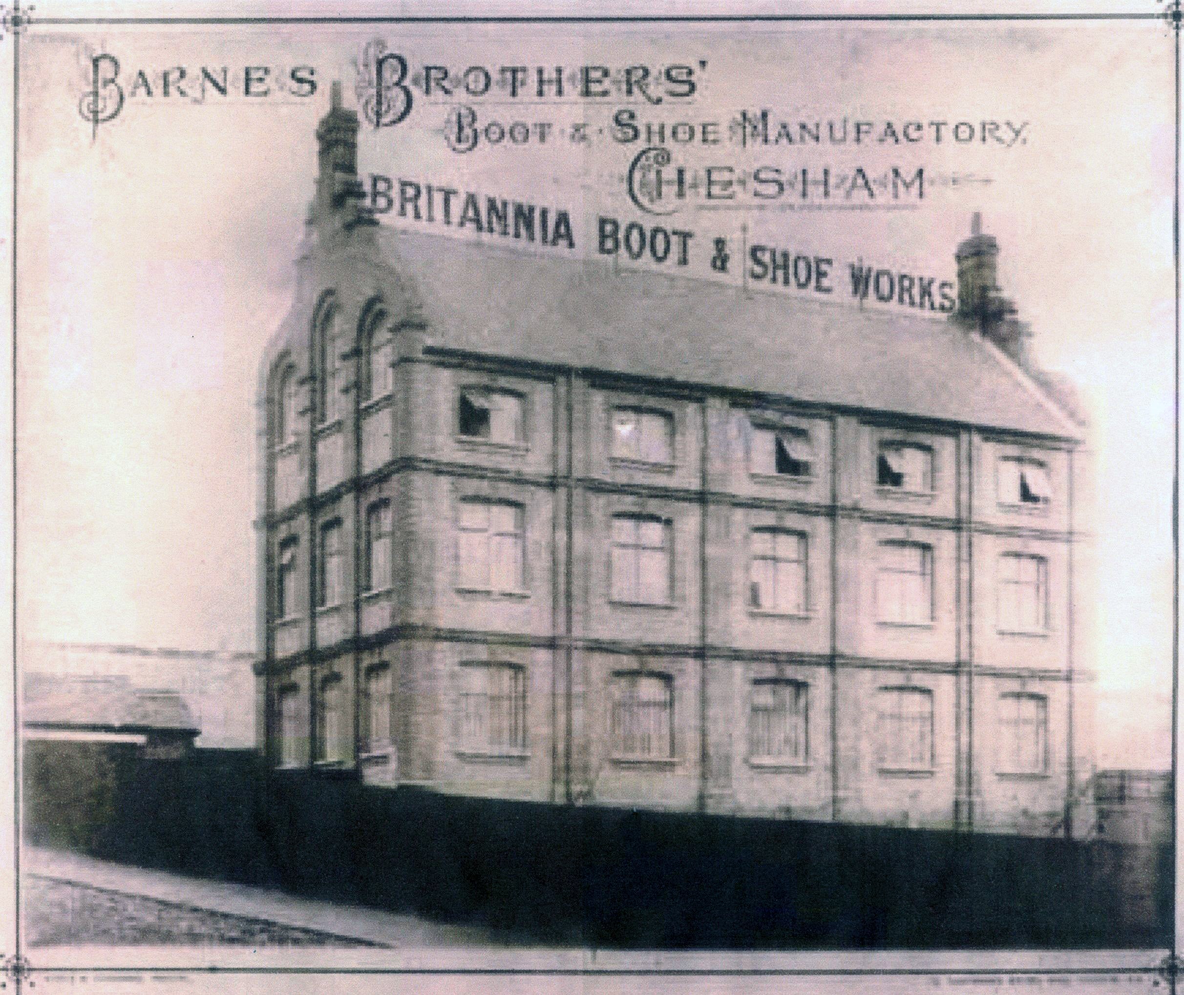 Photo of Barnes Brothers factory. Image is in black and white with Britannia Boot and Shoe Works displayed between 2 chimneys