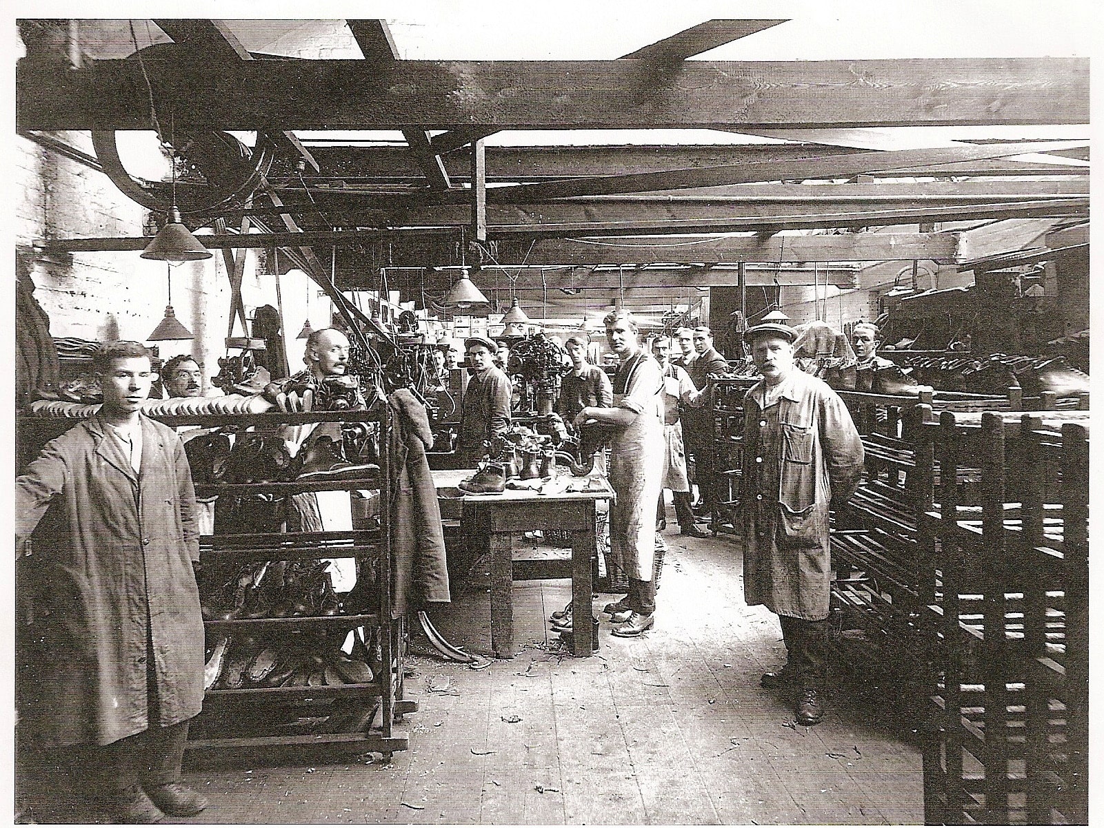 Men working in a boot workshop, looking forward at the camera