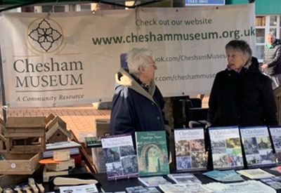 Two ladies on the market stall with Chesham Museum banner in the background