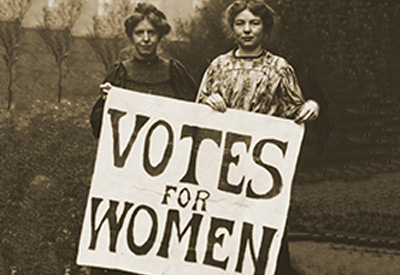 2 women holding up a Votes for Women placard