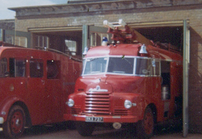 2 stationary red fire engines partly exiting the station