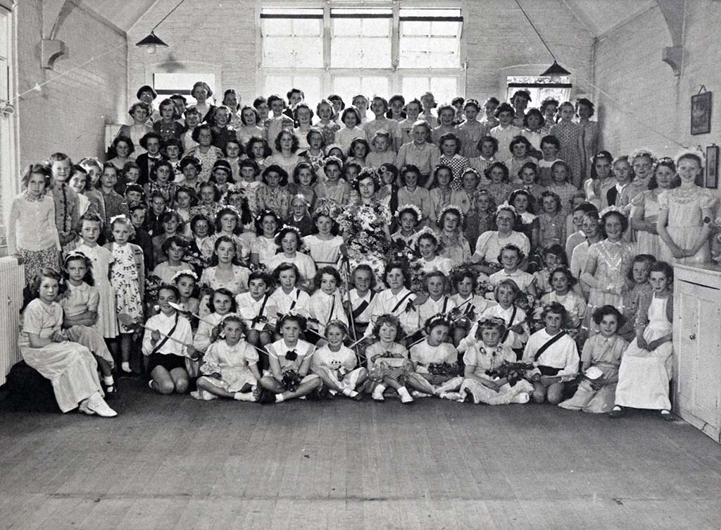 Children in a school hall posing for a photograph