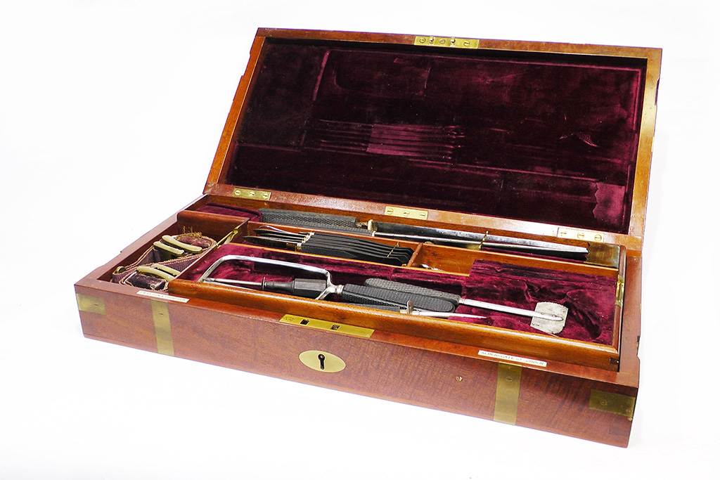 Surgeons equipment box in mahogany with burgundy coloured lining and medical instruments inside