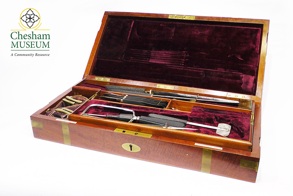 Mahogany field surgeon's equipment box lined with a burgundy material displaying medical instruments