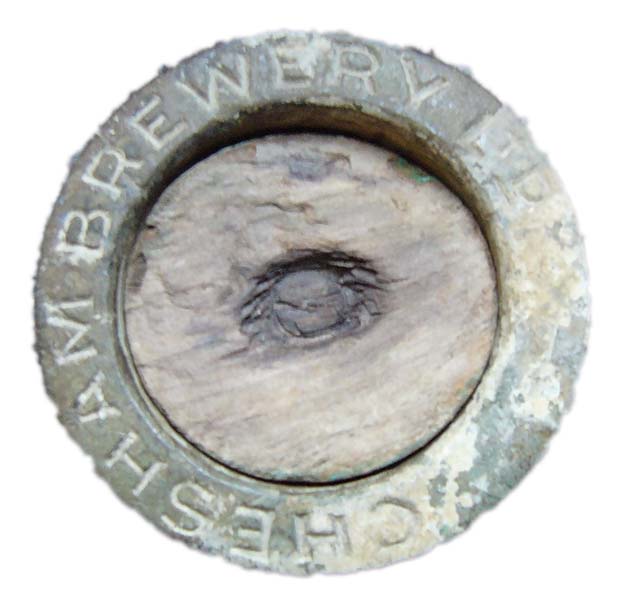 A worn beer barrel stopper with the words Chesham Brewery visible