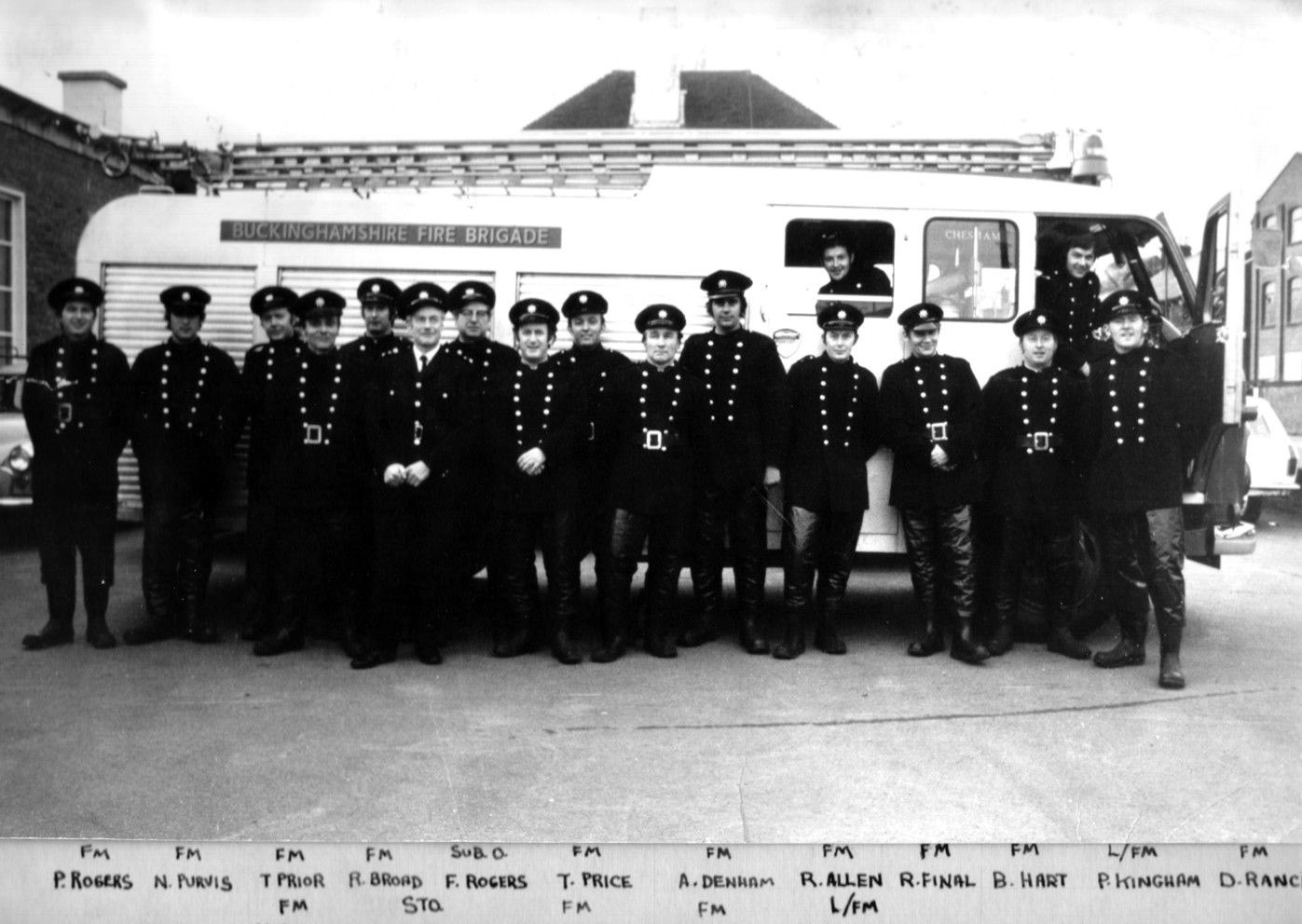 Black and white photo of fire engine with firemen standing alongside