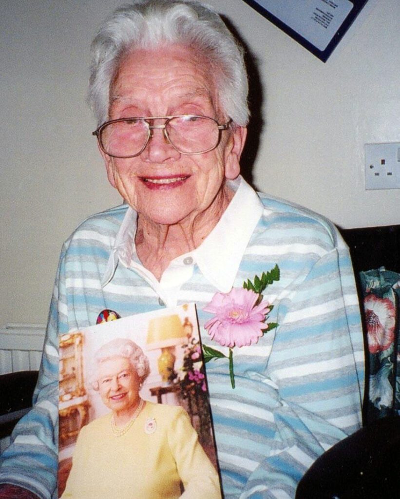 Photo of Hilda Flello holding a picture of the Queen
