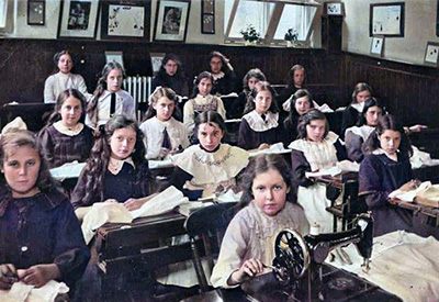 A group of girls with their sewing machines sewing material