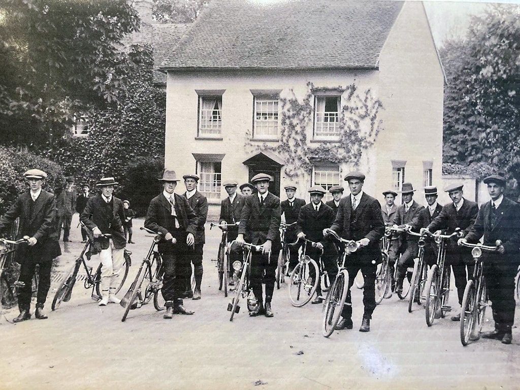 Men standing astride their bicycles