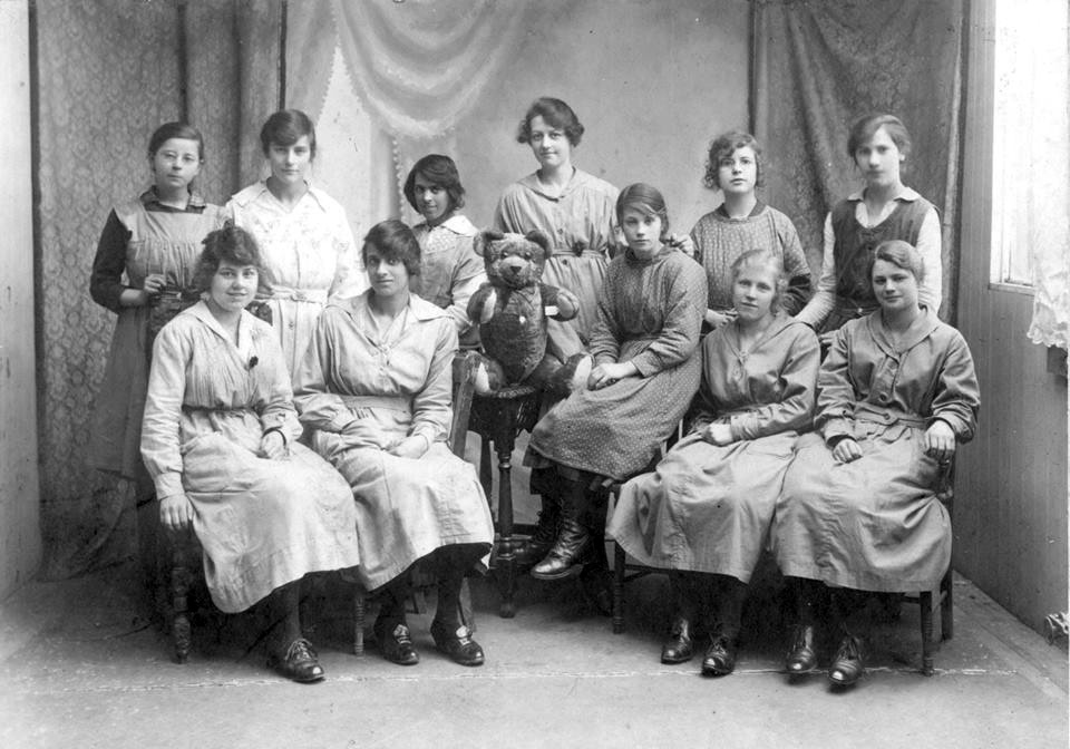 Workers in the toy factory posing for a photo with a teddy bear