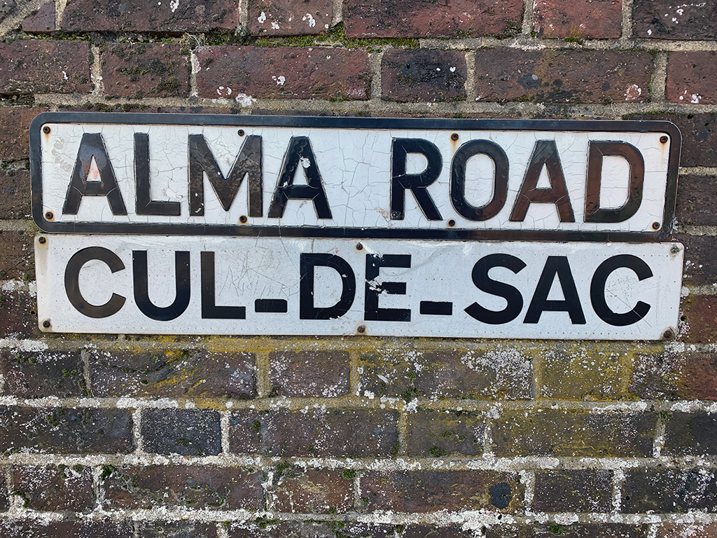 Alma Road cul-de-sec road sign attached to a wall