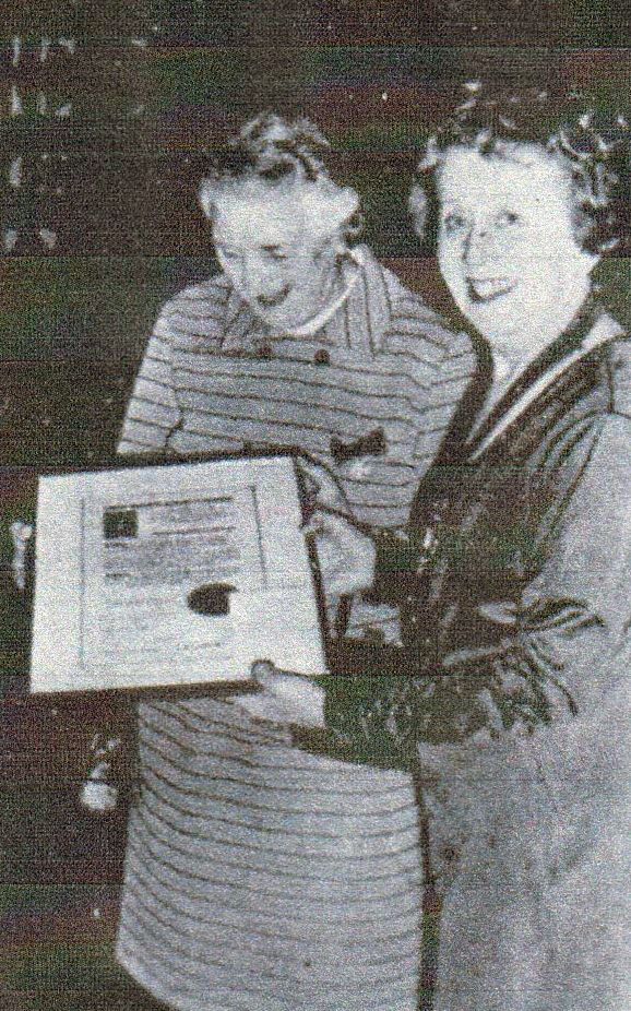 Photo of Mildred Wheeler with another woman who is presenting her with framed document