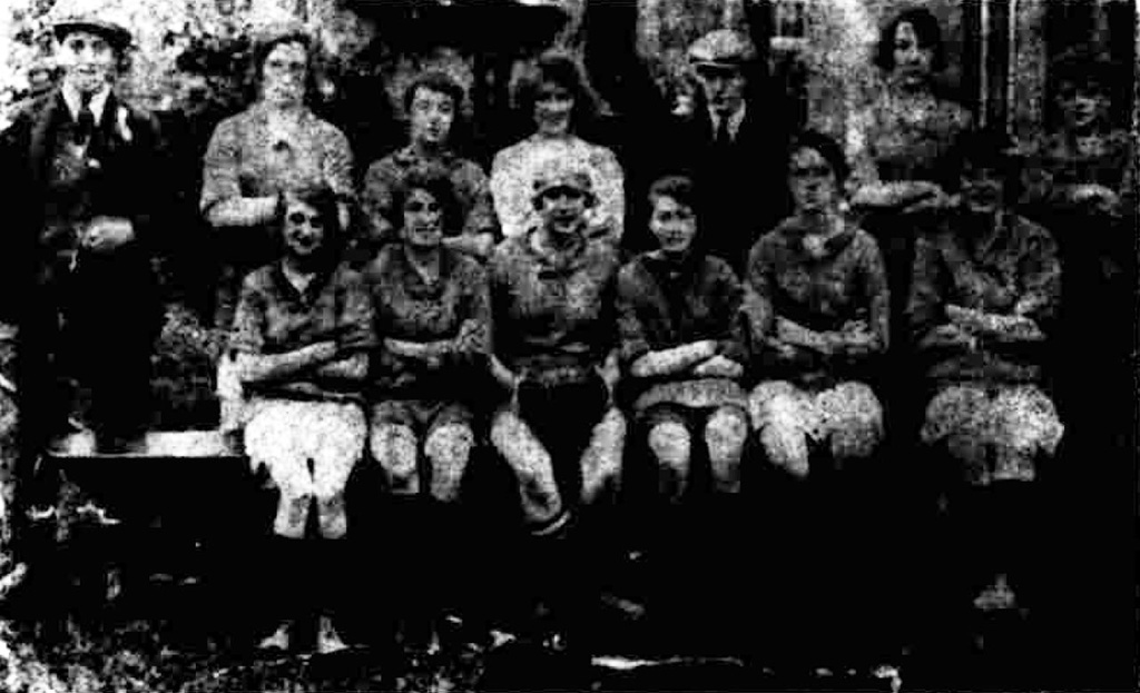 A photo of the Moor Ladies football team - 11 women and 2 men are in the photo, 6 women seated with the rest stood behind them