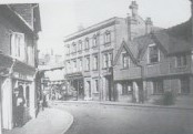 Photo of Chesham High Street with various buildings either side of a road.