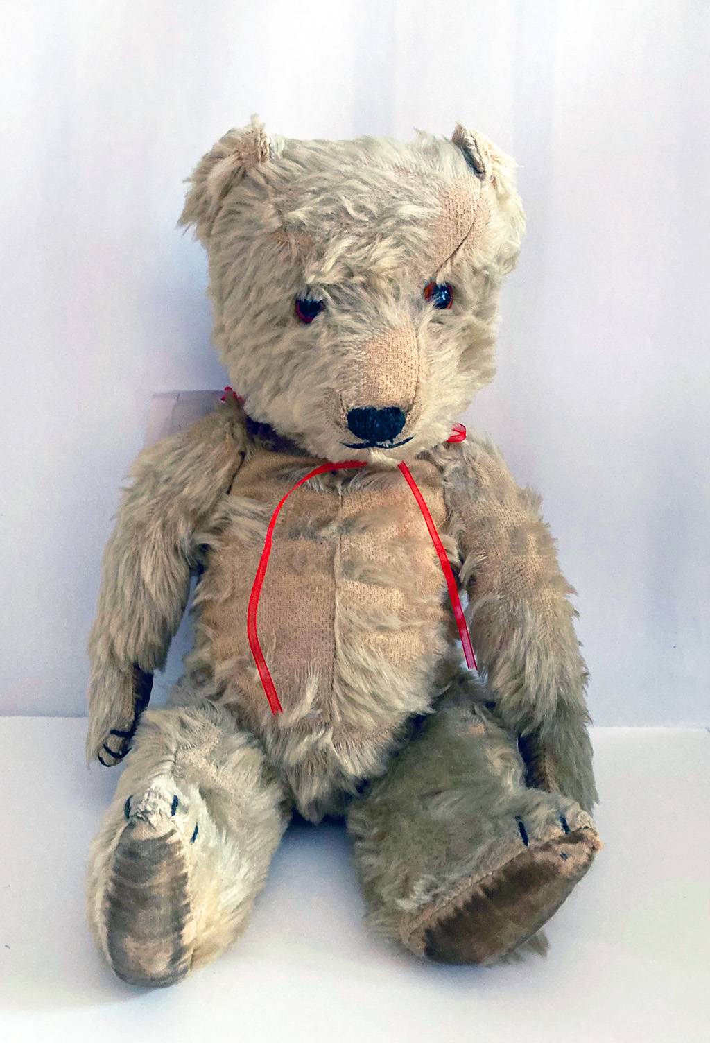 A teddy bear with a red ribbon.